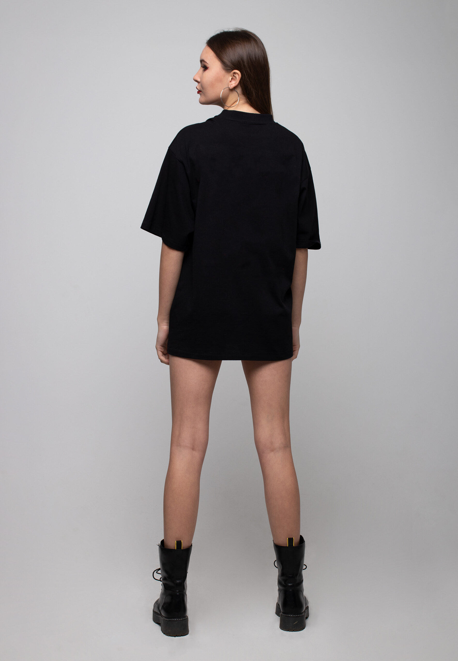 Back view of a black oversized cotton t-shirt with a white woman silhouette print